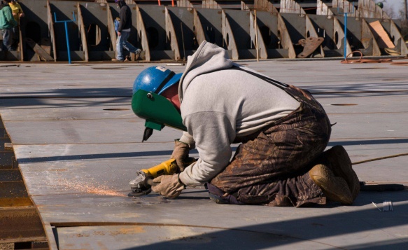 An engineer welds two parts together during construction of Pasha Hawaii's Marjorie C vessel